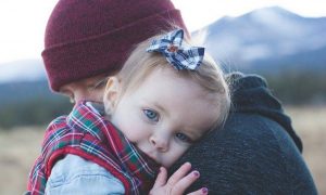 man carrying hugging little adorable daughter