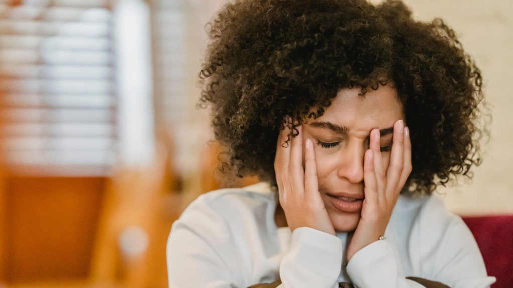 woman stressed hands on face upset worried distressed catastrophise catastrophize uncertain