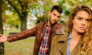 couple haves conflict in public park man trying to explain while woman angrily waking away