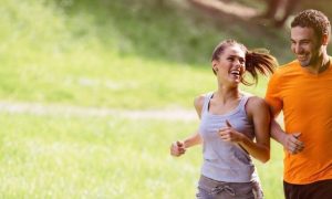 couple happily exercises jogging in park in sunny sky