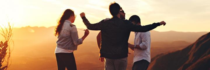 people stands on mountain top talking in sunny sky