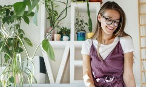 young woman shy face sitting laughing modelling in artwork room