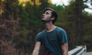 man stands in forest look at sky