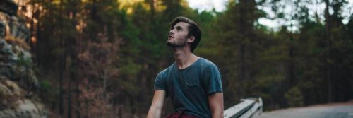 man stands in forest look at sky