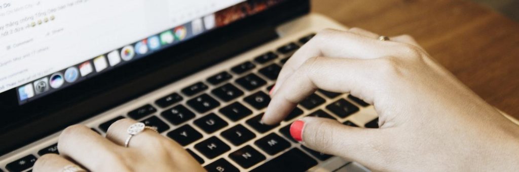 two hands typing on laptop keyboard sending messages