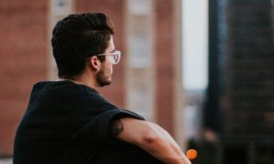 man sitting alone in city thinking