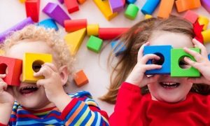 two adorable children play toys legos