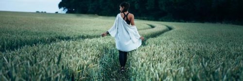 woman facing backward walk on green field