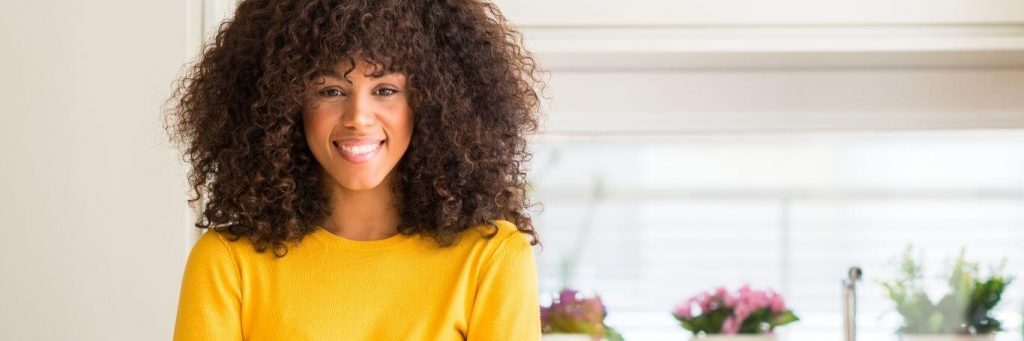 curly hair woman happy face smiles colorful plant pots