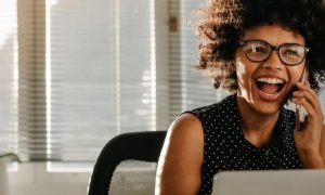 woman happy exciting face answering phone while sitting in office