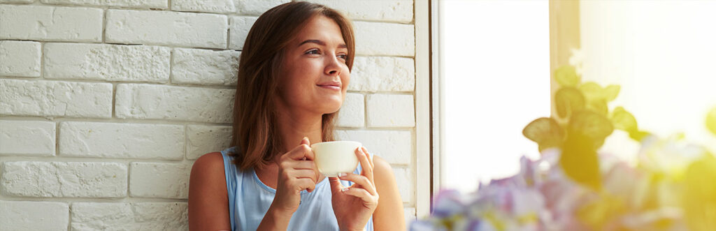 How to Overcome the Stress of Negative Thinking while woman is relaxing and drinking a cup of coffee