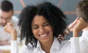 woman of colour celebrating success professional white shirt