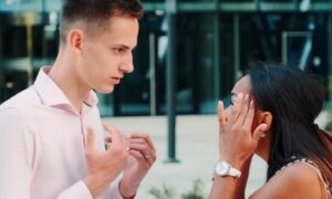 couple stands outside modern office building fights explains to each other