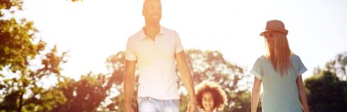 parents little adorable daughter holds hand walking happily in park in beautiful sunny weather