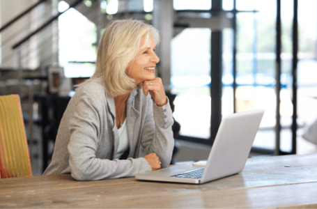 Happy confident woman sitting at desk at work