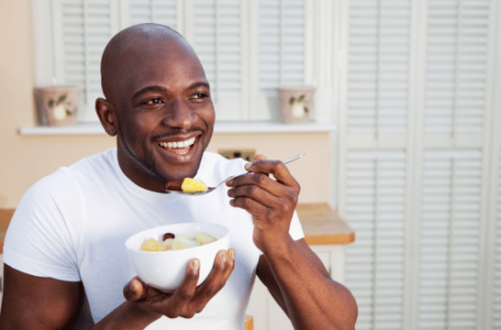 Happy man eating breakfast