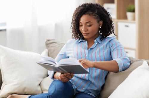 Woman sitting on a couch reading a book