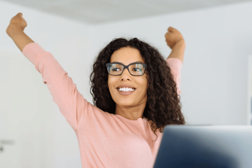 woman with black hair and glasses stretching from her desk