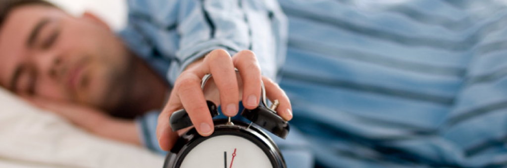 man sleeps while holding clock