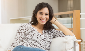 young woman with happy face smiles poses on white coach