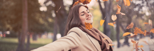 woman wearing scarf stand nearby forest gratitude fall leaves flying