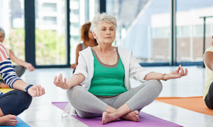 group of five ladies with different ages sit leg crossed meditate peacefully