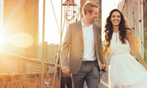 happy couple hand in hand walks along the bridge in sunny sky