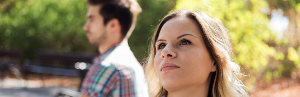 couple sits in park unhappily not talk to each other has conflict in sunny sky