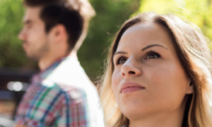 couple sits in park unhappily not talk to each other has conflict in sunny sky