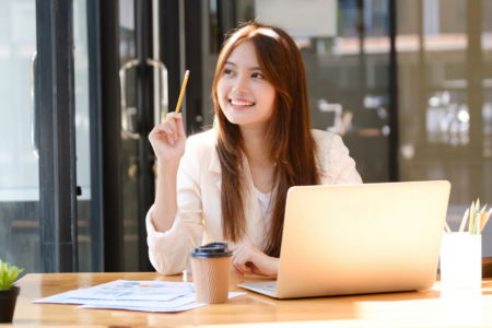 Happy businesswoman relaxing at office desk.