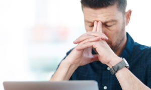 Shot of a businessman experiencing stress while working in a modern office