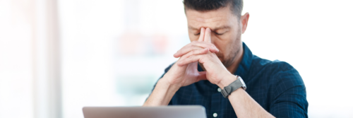 Shot of a businessman experiencing stress while working in a modern office