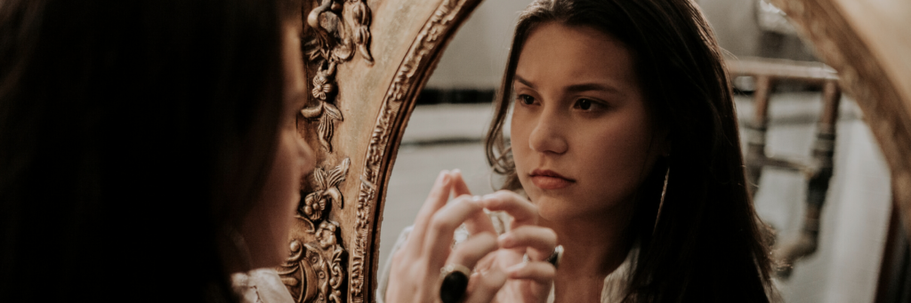 Woman looking at reflection in mirror