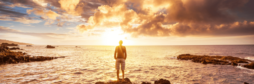 Man looking at golden sunrise