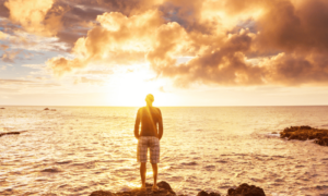 Man looking at golden sunrise