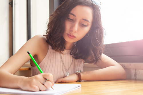 young beautiful women writing something and doing homework. Modern girl working on his job