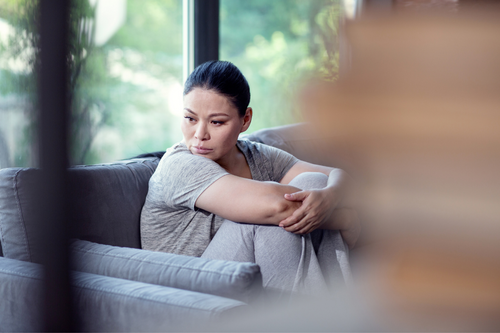 Depressed mood. Pensive mournful woman sitting and staring aside