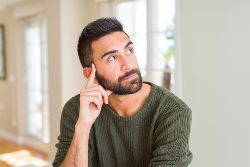 Handsome man thinking confused about doubt, questioning an idea