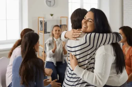 two woman from a group of people hugging