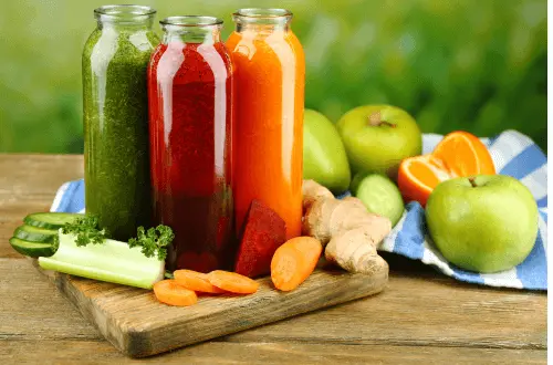 coloured bottles of healthy juice and fruit and vegetables