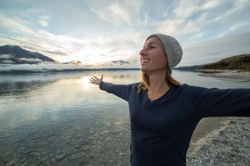 woman with outstretched arms amongst nature.